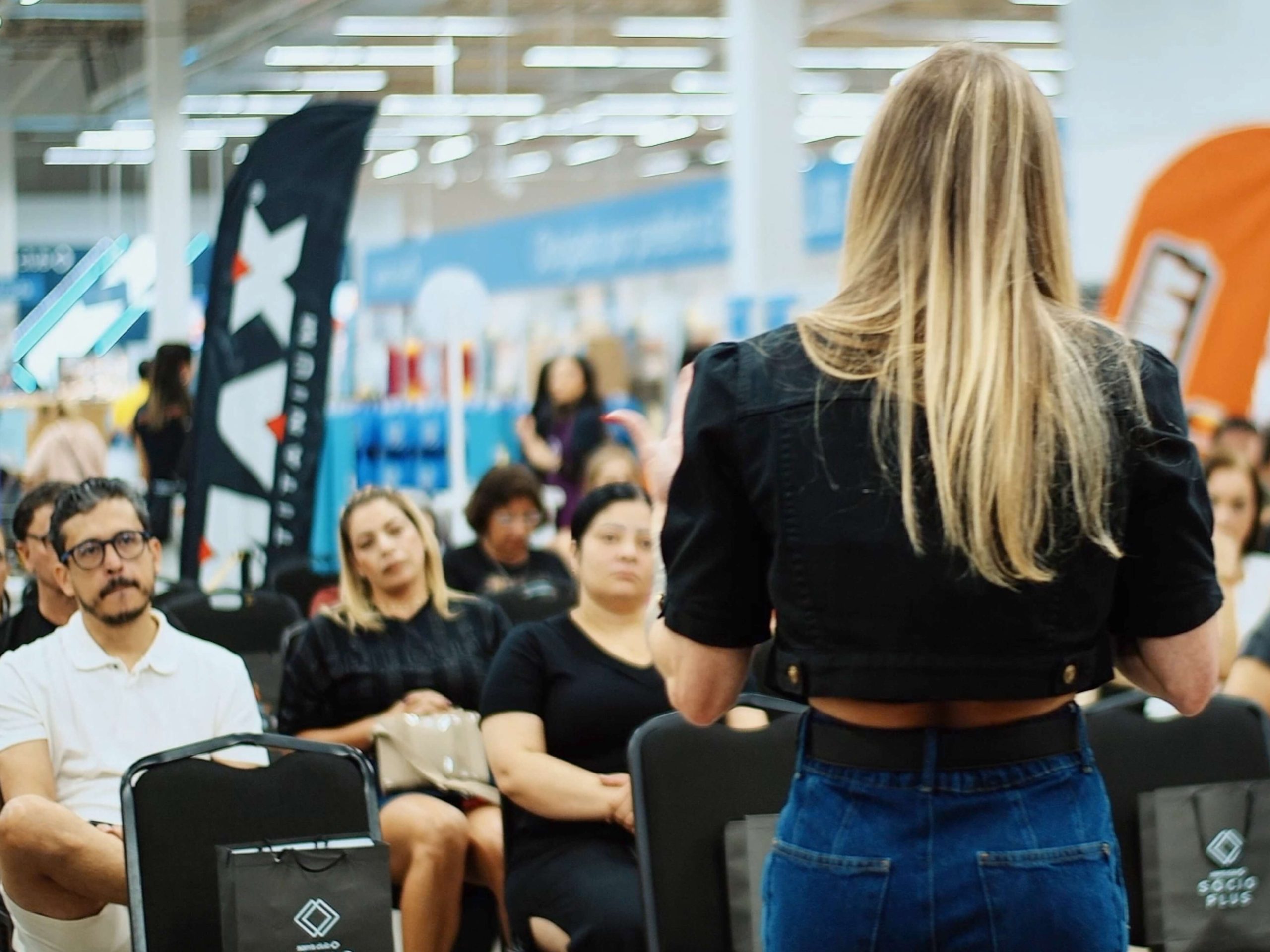 Palestrante fala para público sentado durante evento especial em loja do Sam’s Club